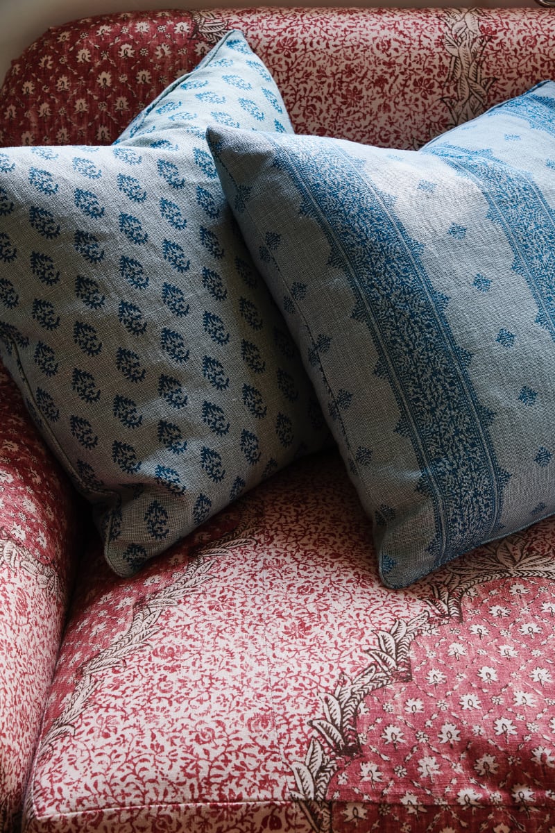 Blue printed linen pillows on red printed linen sofa