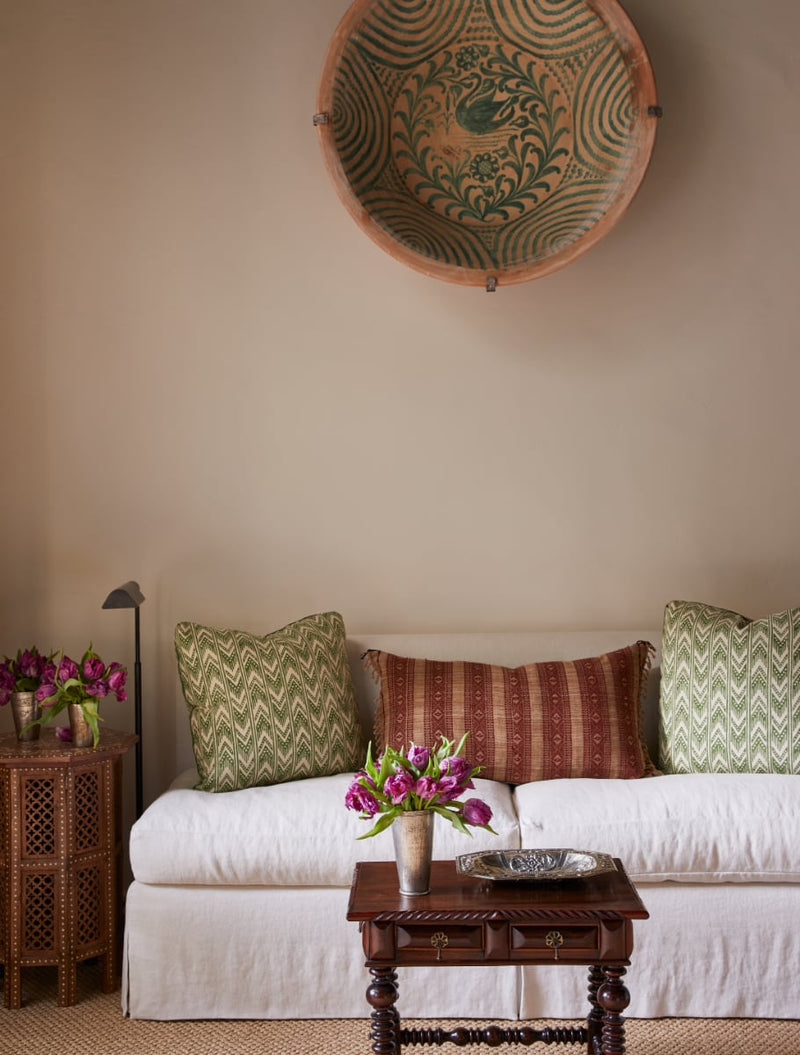 Linen upholstered sofa with pottery on wall above