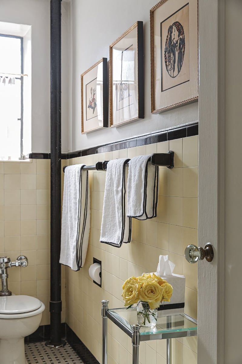 Towels hanging in bathroom with yellow wall tile